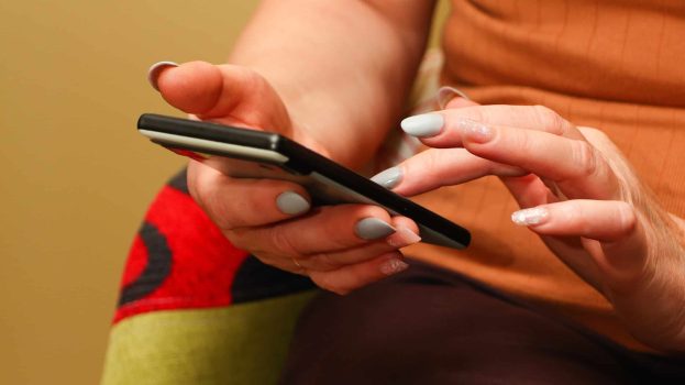 Woman using a smart phone - Call Us or Book an Appointment
